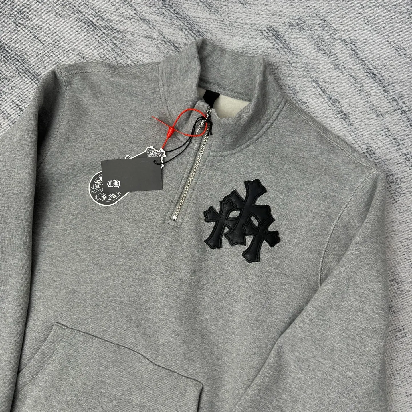 P406 Chrome Heart FW25 leather cross half-zip sweatshirt Size: S/M/L/XL Made of high-weight pure cotton terry fabric Pre-shrunk to ensure wearing stability Three-dimensional leather cross label Half-zip neckline with dagger-shaped zipper pull Combined with curved hem tailoring and kangaroo pocket